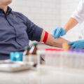 Man sitting in a chair while his blood is being drawn for donation