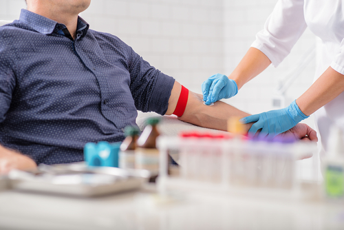 Man sitting in a chair while his blood is being drawn for donation
