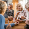 Happy seniors having fun while playing card game at home.