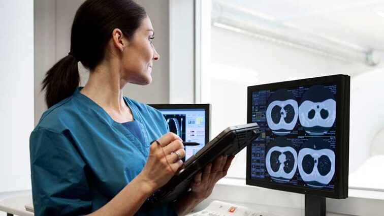 Radiologist looking at CT scans on a monitor