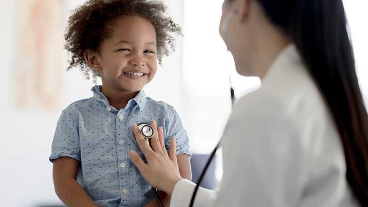 Pediatrician examining a smiling male child