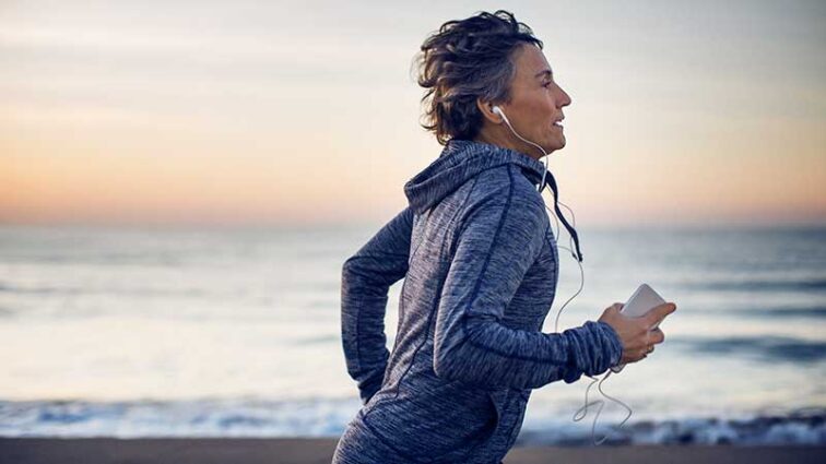 Middle aged woman running along a beach